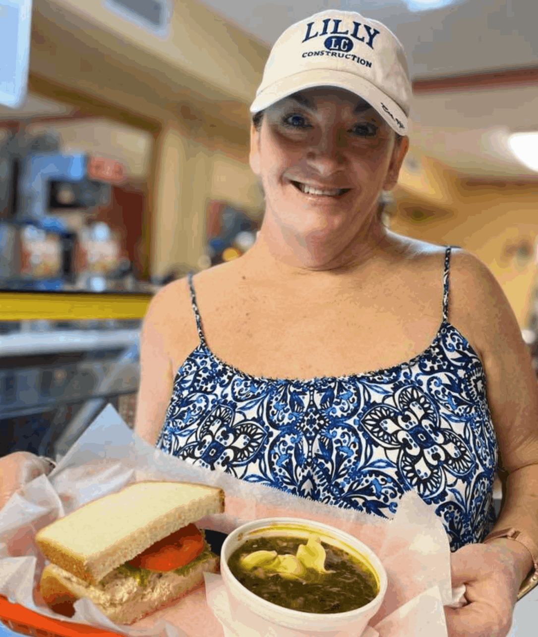 owner kelly harris hold a tray with half and sandwich and a cup of soup